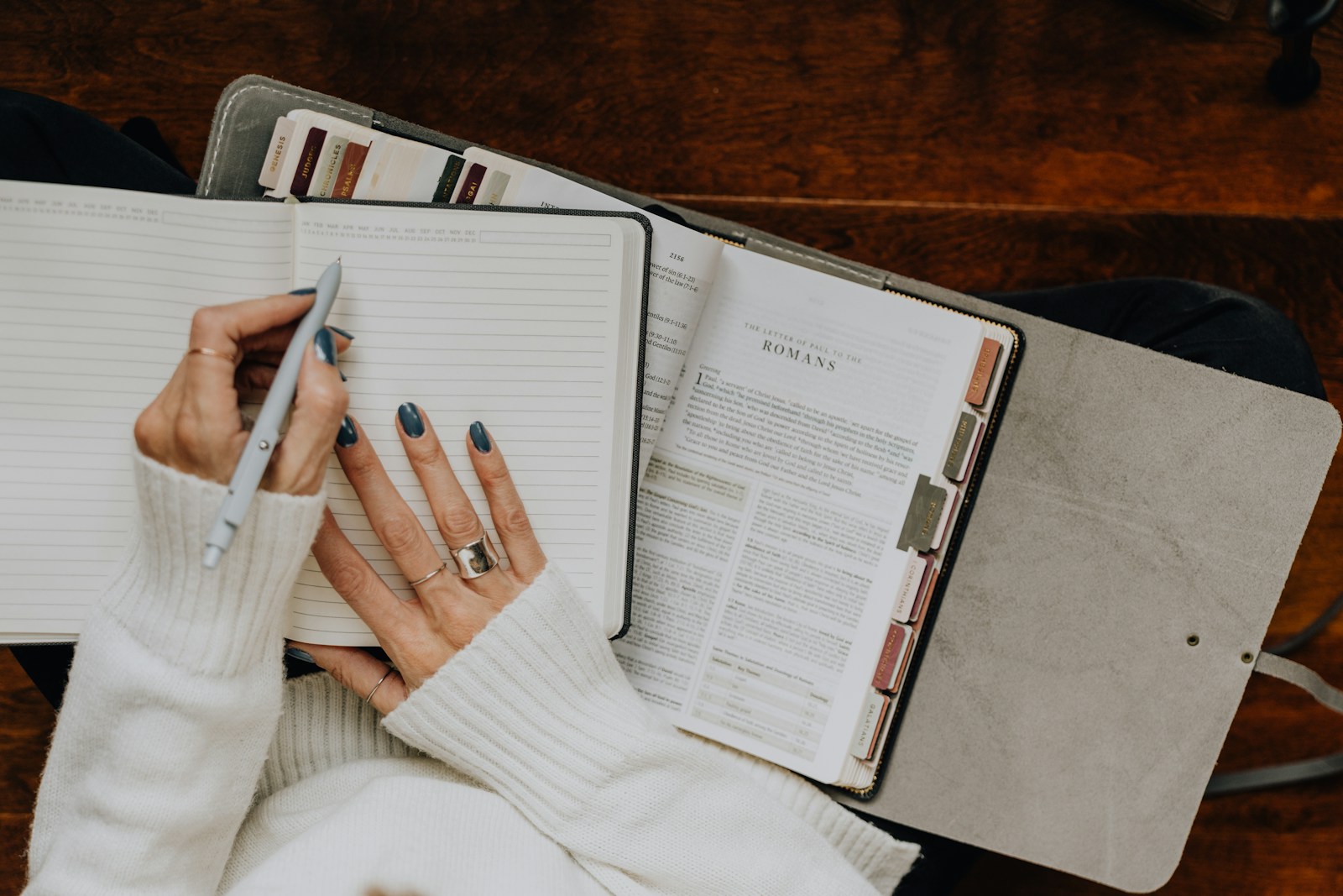 A woman sitting at a table with a notebook and pen